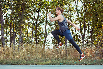 Image showing Running sport. Man runner sprinting outdoor in scenic nature. Fit muscular male athlete training trail running for marathon run.