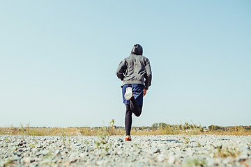 Image showing Running sport. Man runner sprinting outdoor in scenic nature. Fit muscular male athlete training trail running for marathon run.