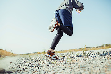 Image showing Running sport. Man runner sprinting outdoor in scenic nature. Fit muscular male athlete training trail running for marathon run.