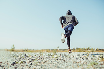 Image showing Running sport. Man runner sprinting outdoor in scenic nature. Fit muscular male athlete training trail running for marathon run.