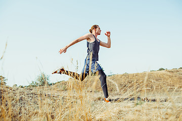 Image showing Running sport. Man runner sprinting outdoor in scenic nature. Fit muscular male athlete training trail running for marathon run.