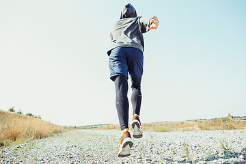 Image showing Running sport. Man runner sprinting outdoor in scenic nature. Fit muscular male athlete training trail running for marathon run.