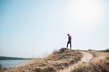 Image showing Running sport. Man runner sprinting outdoor in scenic nature. Fit muscular male athlete training trail running for marathon run.