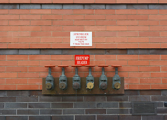 Image showing Firepump test headers on red brick wall