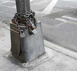 Image showing Heavy metal chain and padlock wound around pole