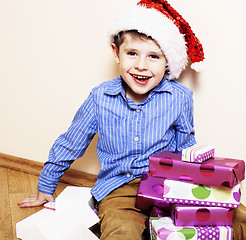 Image showing little cute boy with Christmas gifts at home. close up emotional