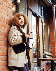 Image showing young pretty african american women drinking coffee outside in cafe, modern real business woman lifestyle concept