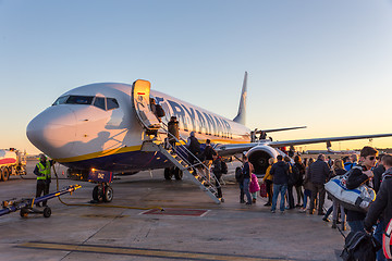 Image showing People boarding on Ryanair Jet commercial airplane on Valencia airport at sunset.