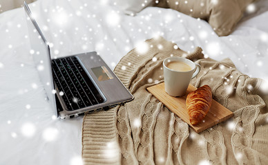 Image showing laptop, coffee and croissant on bed at cozy home