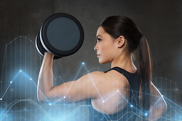 Image showing young woman flexing muscles with dumbbells in gym