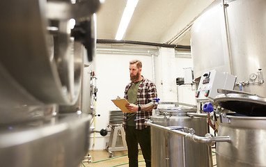 Image showing man with clipboard at craft brewery or beer plant