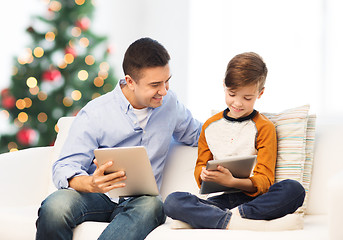 Image showing happy father and son with tablet pc at christmas