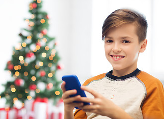 Image showing close up of happy boy with smartphone at christmas