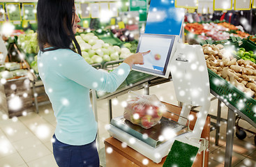 Image showing customer weighing apples on scale at grocery store