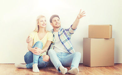 Image showing couple with boxes moving to new home and dreaming