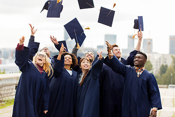 Image showing happy graduates or students throwing mortar boards