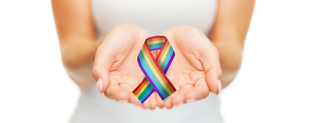 Image showing female hands holding gay pride awareness ribbon