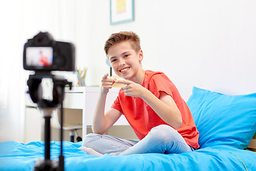 Image showing happy boy with camera recording video at home