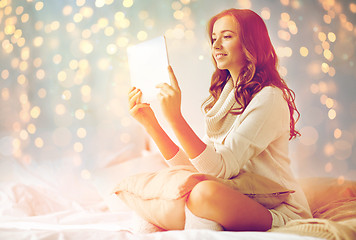 Image showing happy young woman with tablet pc in bed at home