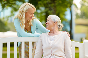 Image showing daughter with senior mother hugging on park bench