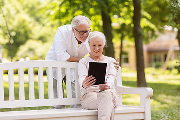 Image showing happy senior couple with tablet pc at summer park