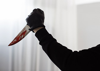 Image showing hand in glove with blood on knife