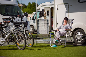 Image showing Woman resting near motorhomes in nature. Family vacation travel,