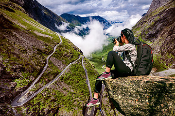 Image showing Nature photographer tourist with camera shoots while standing on