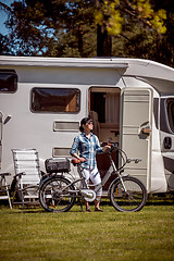 Image showing Woman on electric bike resting at the campsite VR Caravan car Va