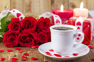 Image showing Cup with coffee in front of bouquet of red roses
