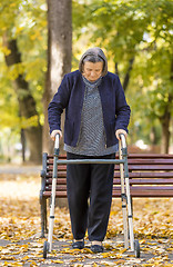 Image showing Woman with walker walking outdoors