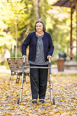 Image showing Woman with walker walking outdoors in autumn park