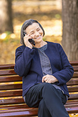 Image showing Senior woman talking on smartphone outdoors