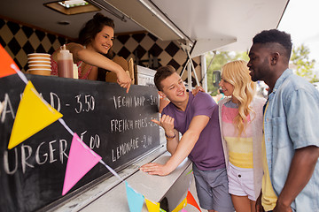 Image showing seller showing menu to customers at food truck