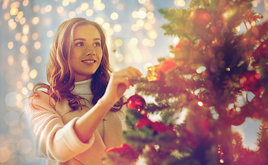 Image showing happy young woman decorating christmas tree
