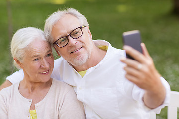 Image showing senior couple taking selfie by smartphone at park