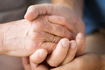 Image showing close up of senior couple holding hands
