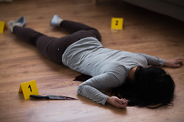 Image showing dead woman body lying on floor at crime scene
