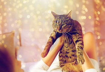 Image showing young woman with cat lying in bed at home