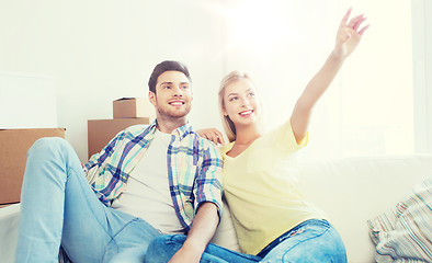 Image showing couple with boxes moving to new home and dreaming