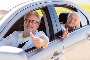 Image showing senior couple driving in car and showing thumbs up