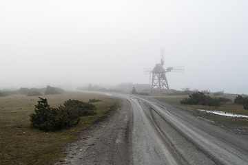 Image showing Old windmill by roadside in the mist