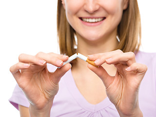 Image showing Young woman is breaking a cigarette