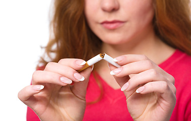 Image showing Young woman is breaking a cigarette