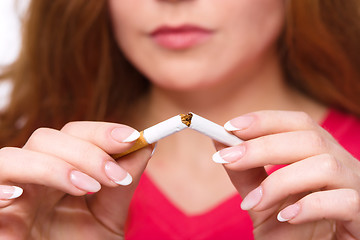 Image showing Young woman is breaking a cigarette