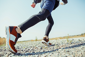 Image showing Running sport. Man runner sprinting outdoor in scenic nature. Fit muscular male athlete training trail running for marathon run.