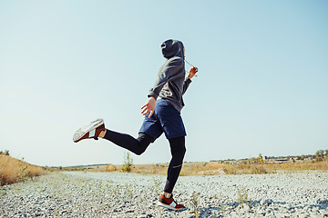 Image showing Running sport. Man runner sprinting outdoor in scenic nature. Fit muscular male athlete training trail running for marathon run.