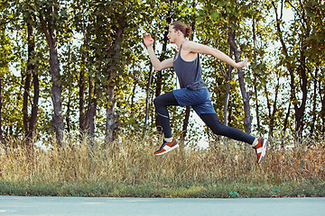 Image showing Running sport. Man runner sprinting outdoor in scenic nature. Fit muscular male athlete training trail running for marathon run.