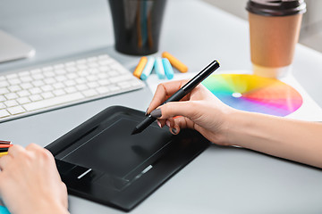 Image showing The gray desk with laptop, notepad with blank sheet, pot of flower, stylus and tablet for retouching