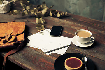 Image showing Opened craft paper envelope , autumn leaves and coffee on wooden table